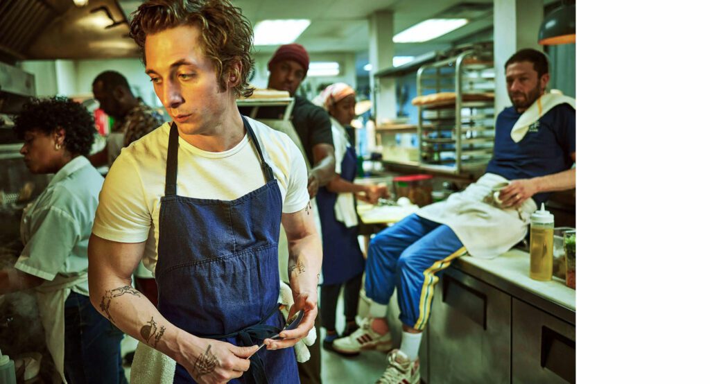 Jeremy Allen White in the kitchen with other chefs, from the tv show The Bear.