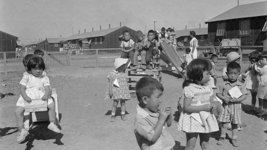 Japanese American children playing in a kindergaten playground at Tule Lake Segregation Center, Newell, California during the World War II. September 1944.