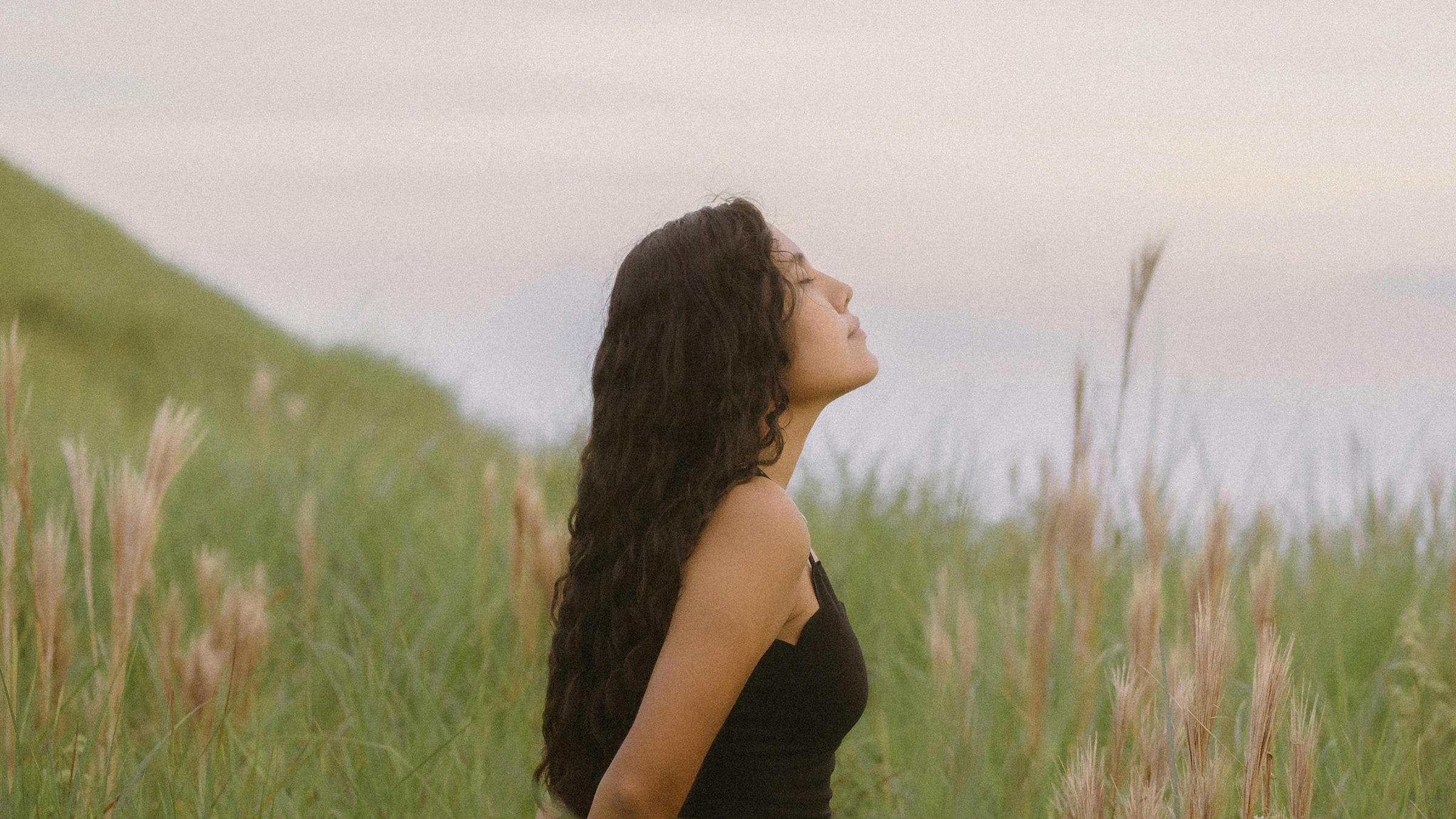 woman standing in grass breathing