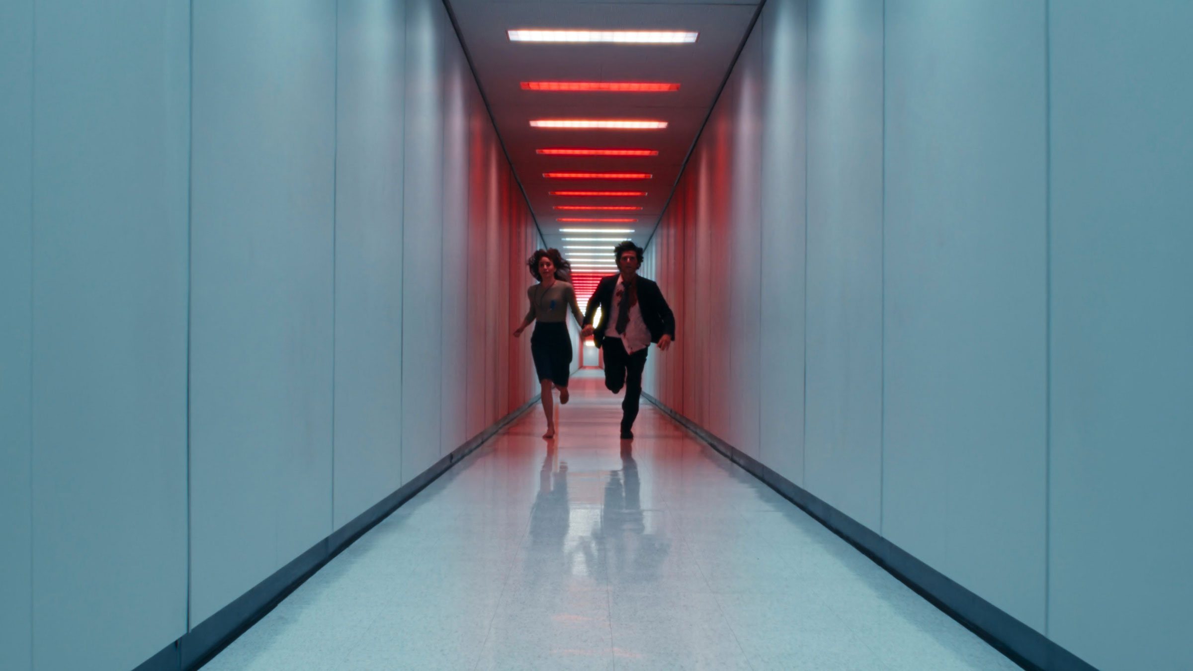 two people running down the long hallway, scene from the Apple TV+ show Severance